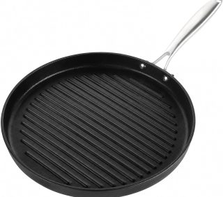 Round cast iron grill pan with stainless steel handle, pre-seasoned ribbed surface for steak and burgers.